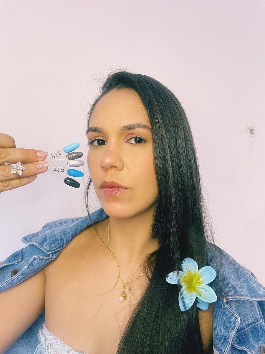 Lysia Silva, nail designer, segurando cartela de cores